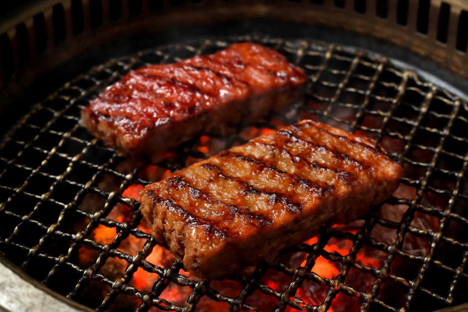 焼肉プレートで焼かれるカイノミとハラミの焼き加減を示す調理シーン