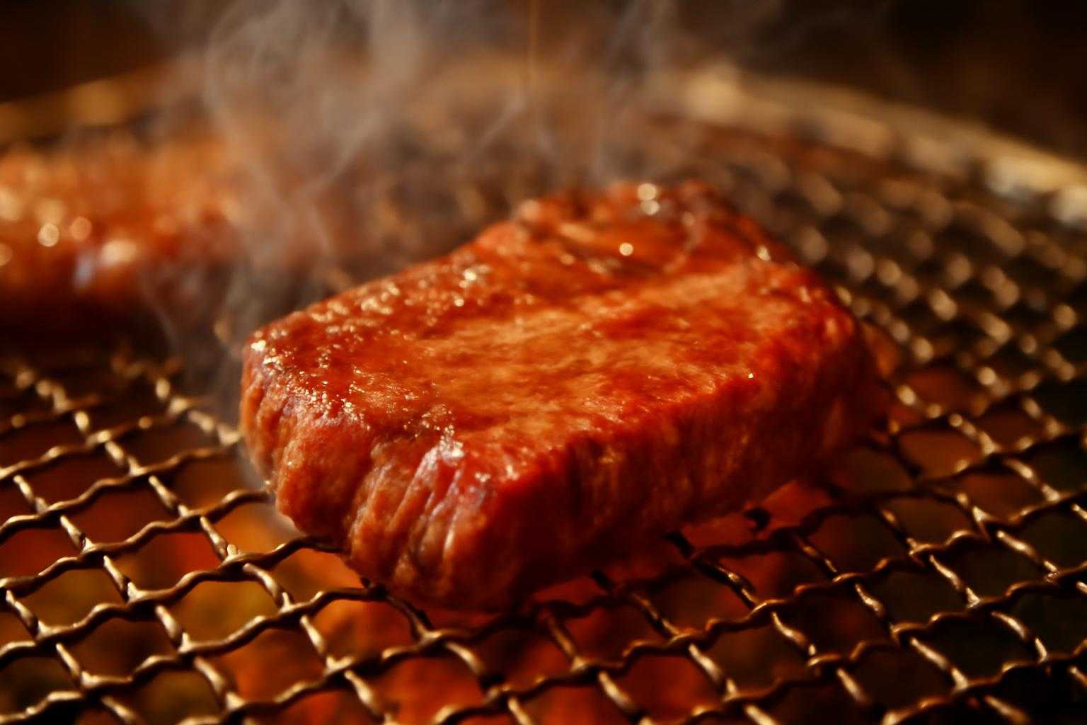 焼肉用の赤身肉を焼き網で焼く調理風景