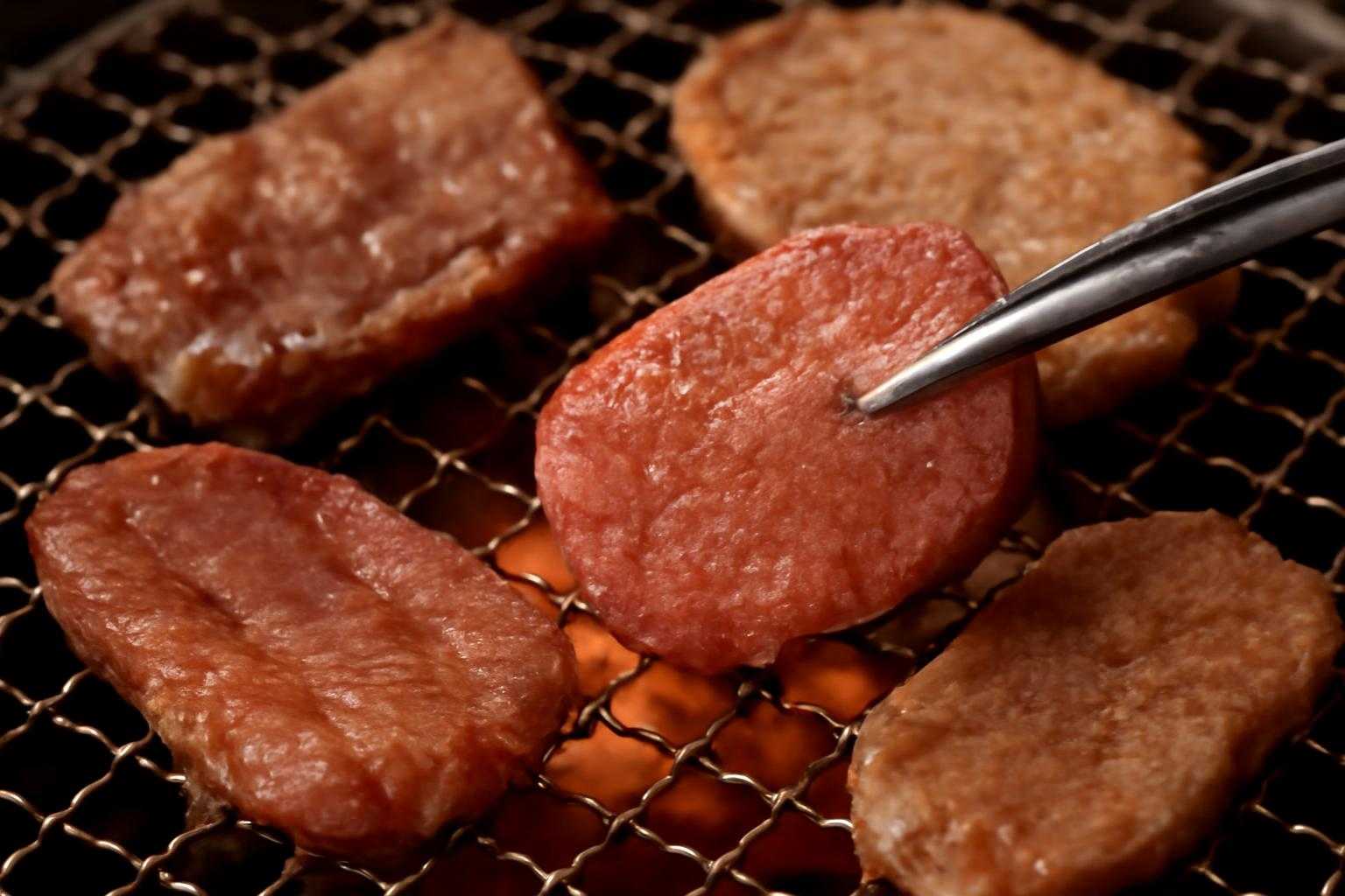 焼肉用トングと牛タン、上タンが焼肉グリルに乗っている