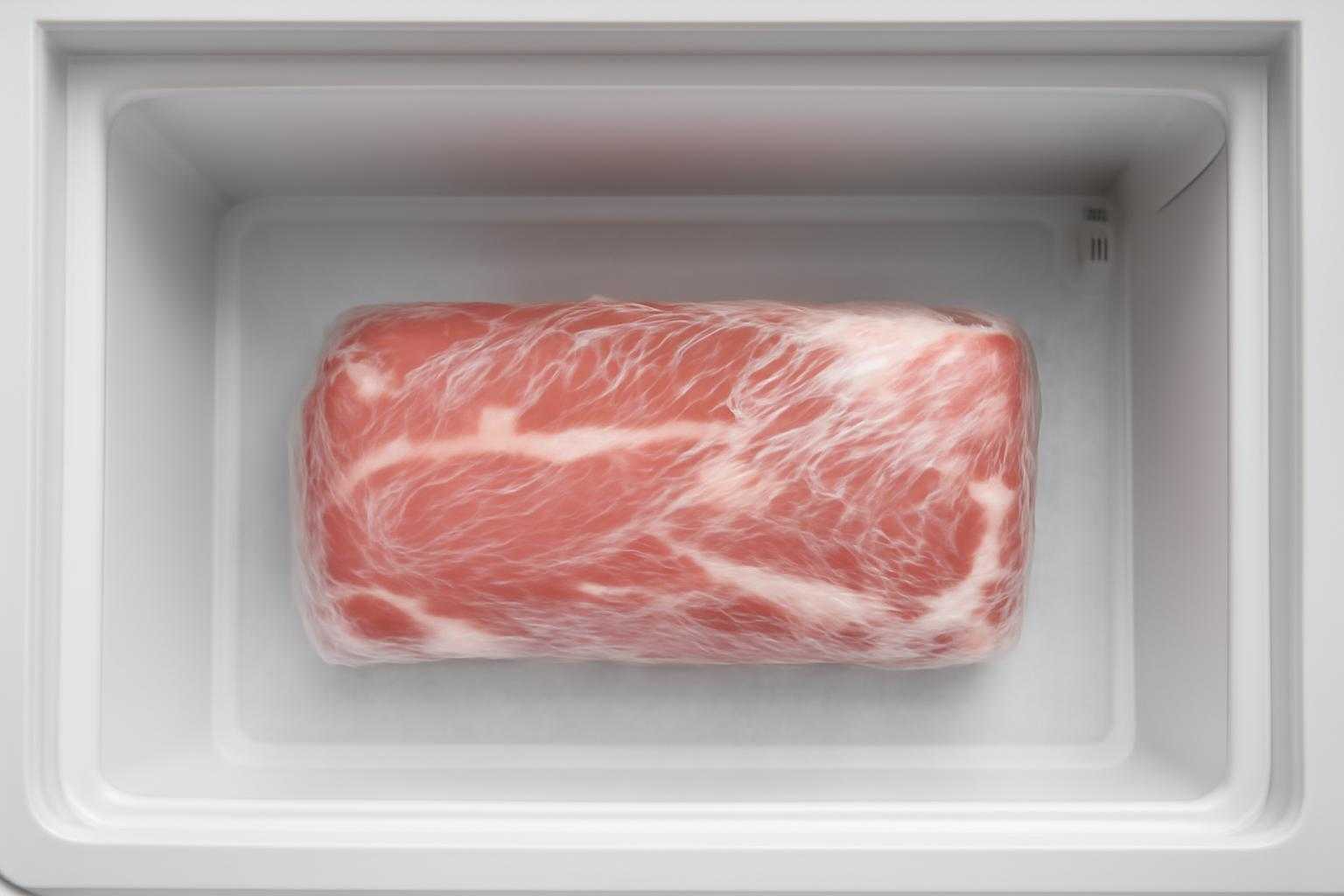 豚肉をラップで包み、冷凍庫に保存している様子